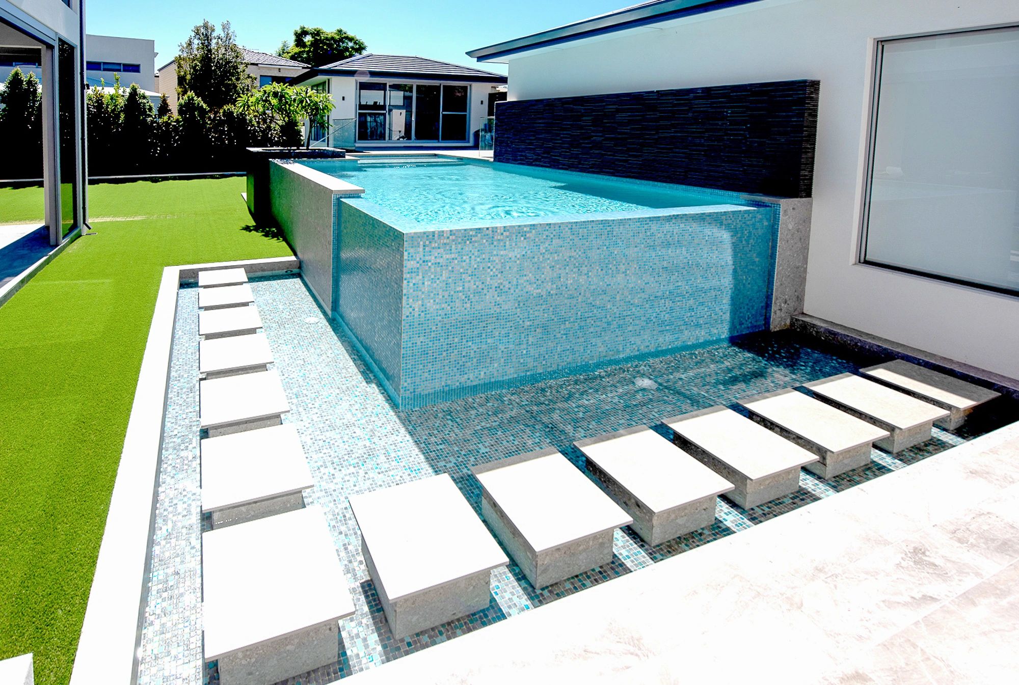 Elevated glass mosaic tile pool feature